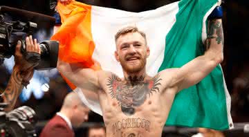 Connor McGregor comemora com a bandeira da Irlanda após vencer luta - Getty Images