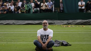Manifestante do "Just Stop Oil" sentado na quadra 18 no terceiro dia do campeonato de tênis de Wimbledon, em Londres - Alastair Grant/AP