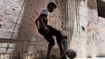 Menino joga bola na região de Gaza em 2018 - Getty Images