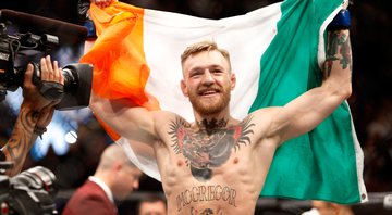 Connor McGregor comemora com a bandeira da Irlanda após vencer luta - Getty Images