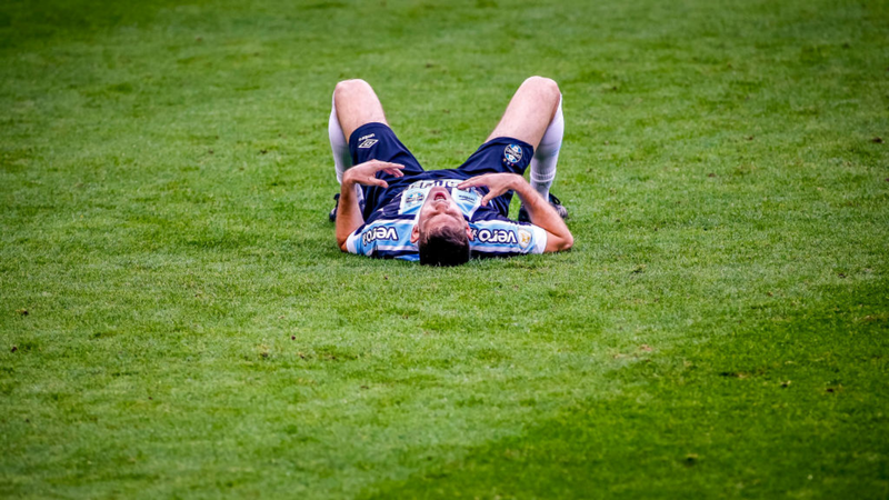 Kannemann, jogador do Grêmio caído no chão sentindo dores - GettyImages
