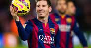Messi na época em que defendia o Barcelona, segurando uma bola e sorrindo - GettyImages