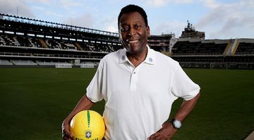 Pelé, ex-jogador de futebol posando com uma bola da seleção no estádio do Santos - GettyImages