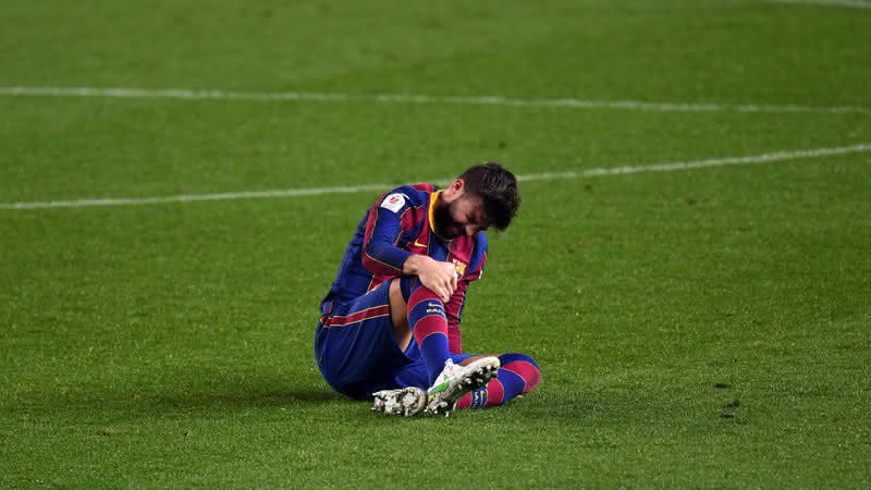 Piqué, jogador do Barcelona sentado em campo com dores - GettyImages