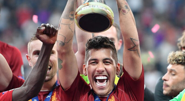 Roberto Firmino, jogador do Liverpool sorrindo e levantando o troféu da equipe - GettyImages