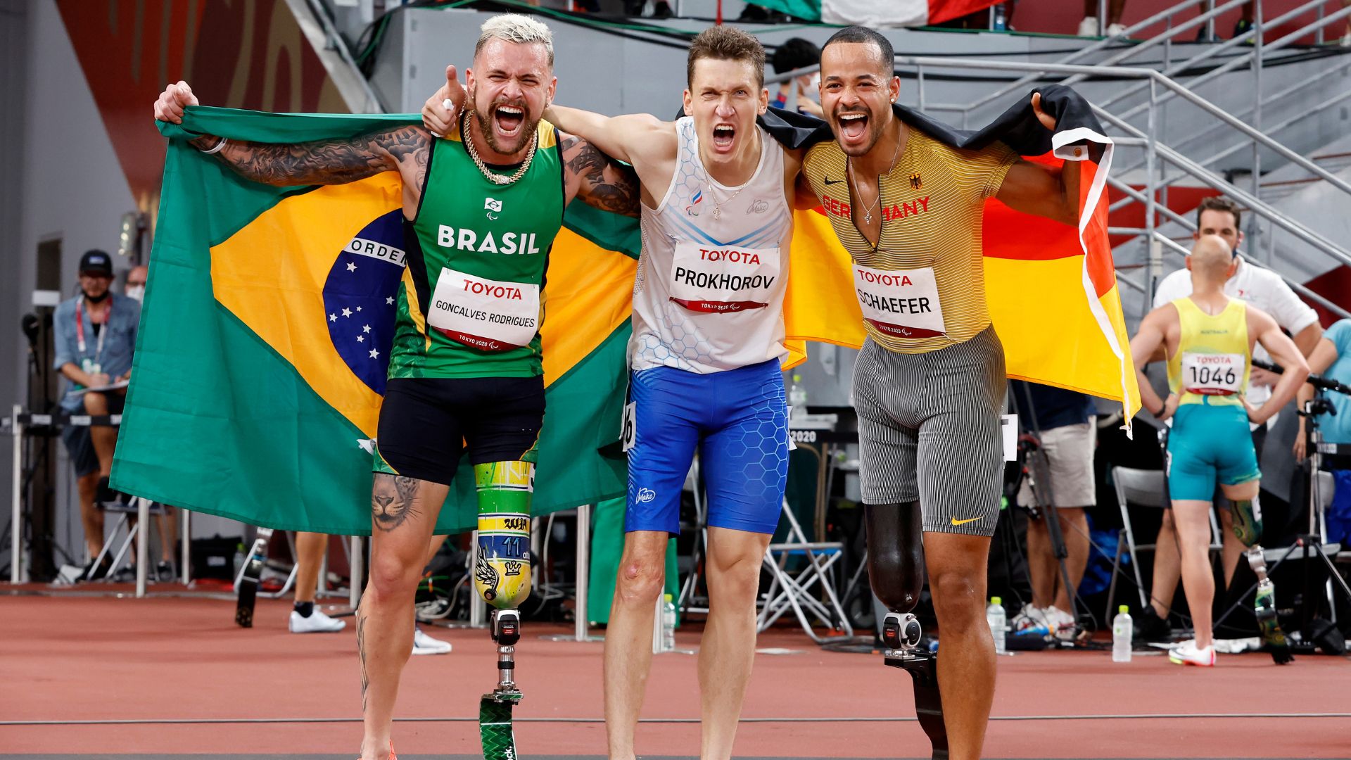 Vinicius Rodrigues junto com os medalhistas dos 100m rasos T63 na Paralimpíada de Tóquio (Crédito: Getty Images)