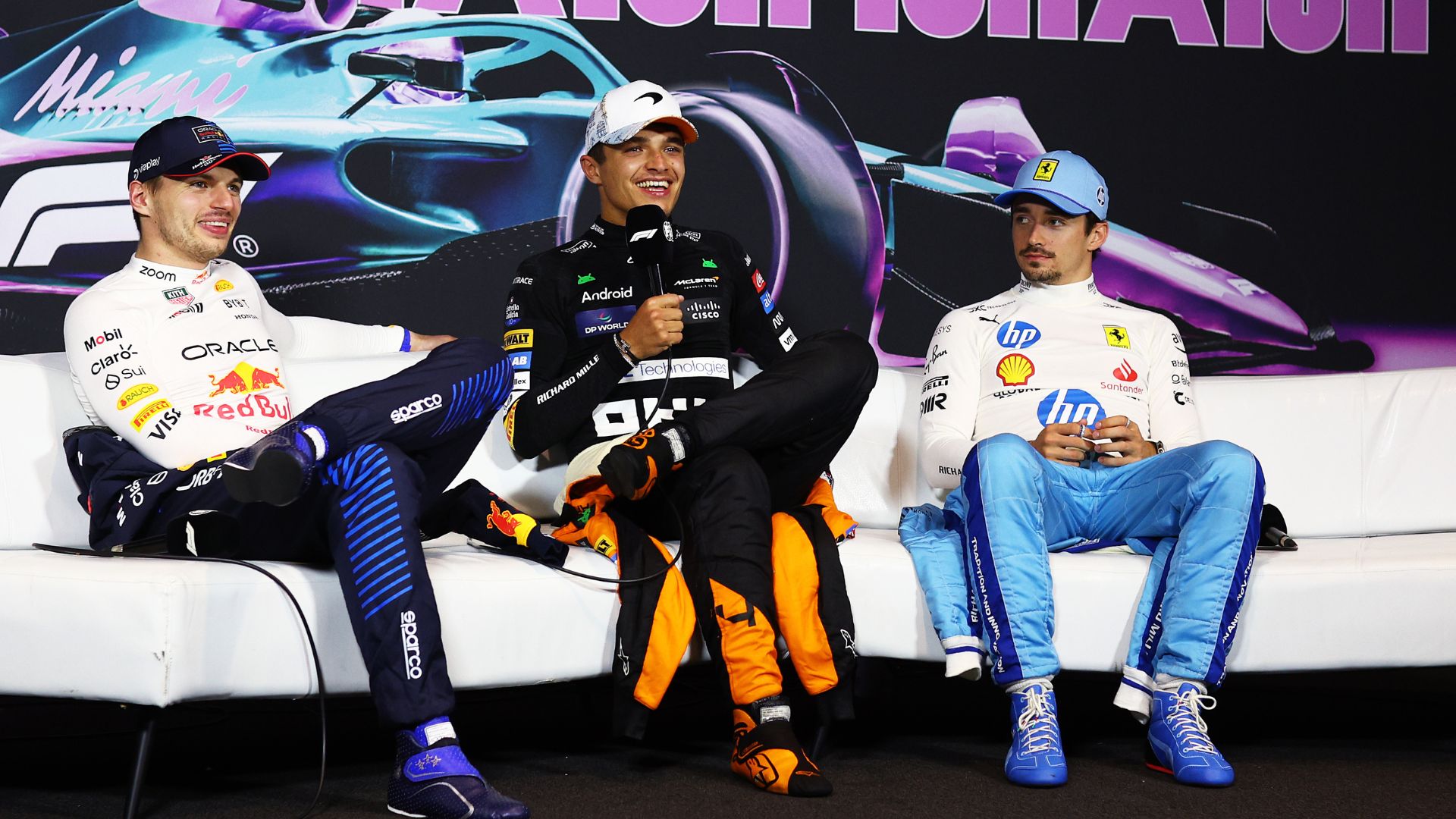Max Verstappen ao lado de Lando Norris e Charles Leclerc, concendendo entrevista após a corrida (Crédito: Getty Images)