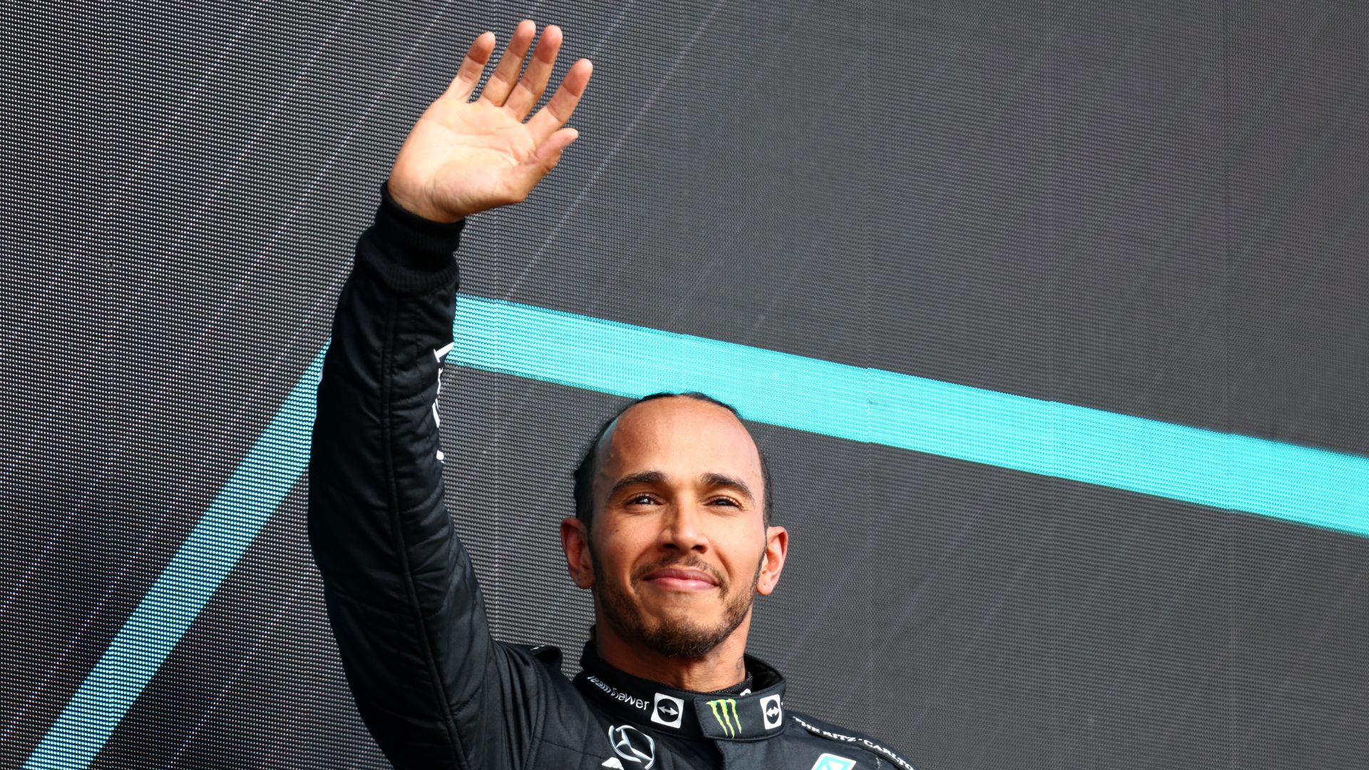 Hamilton, piloto de Fórmula 1 com o braço levantado