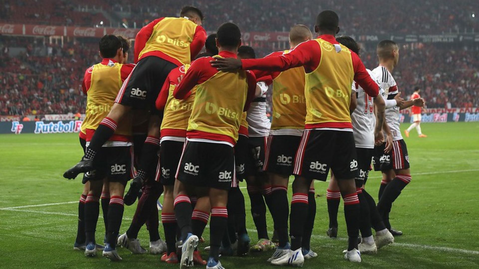 Jogadores do São Paulo reunidos comemorando o gol em campo